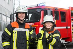 以消防车为背景的两名消防员微笑|消防安全提示